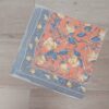 PAÑUELO RASADO ESTAMPADO CON FLORES, FONDO NARANJA. TAMAÑO 70 X 70