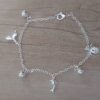 PULSERA DE ACERO BLANCO ESPEJITO CON DIJE DELFIN, COLA DE BALLENA, TORTUGA Y BOLITAS INTGERCALADAS. LARGO 19 CM