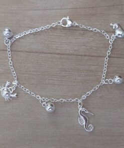 PULSERA DE ACERO BLANCO ESPEJITO CON DIJE BALLENA, HIPOCAMPO, CANGREJO Y BOLITAS INTGERCALADAS. LARGO 19 CM