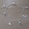 PULSERA DE ACERO BLANCO ESPEJITO CON DIJE ESTRELLA DE MAR, PULPO, PEZ Y BOLITAS INTGERCALADAS. LARGO 19 CM