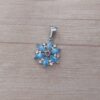 DIJE DE ACERO FLOR CON CUBIK Y STRASS CELESTE. MEDIDA 15 MM