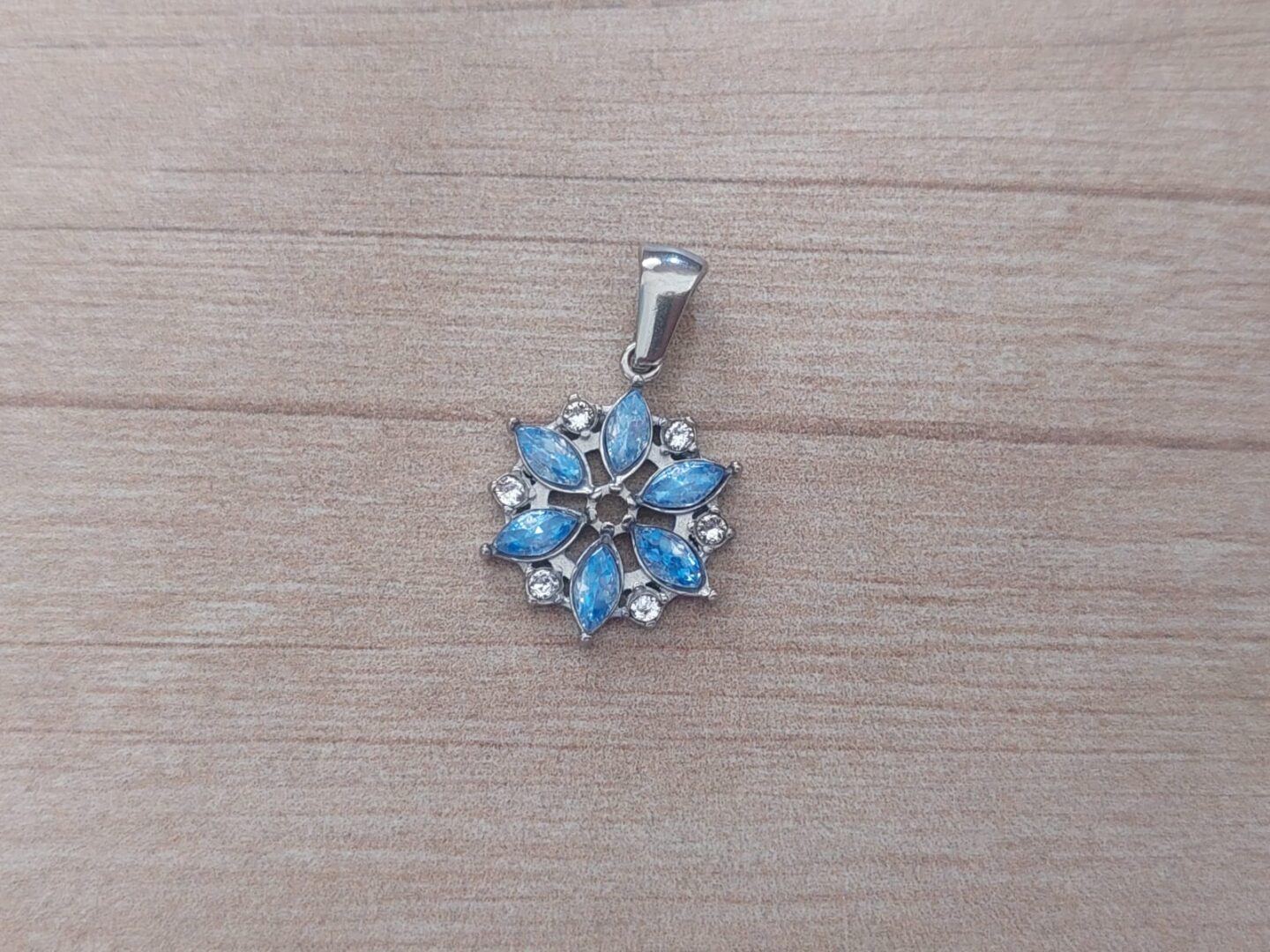 DIJE DE ACERO FLOR CON CUBIK Y STRASS CELESTE. MEDIDA 15 MM