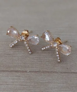 Aro de acero dorado pasante en forma de moño con cubik y strass