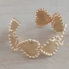 Esclava regulable de acero dorado con corazones y bolitas alrededor