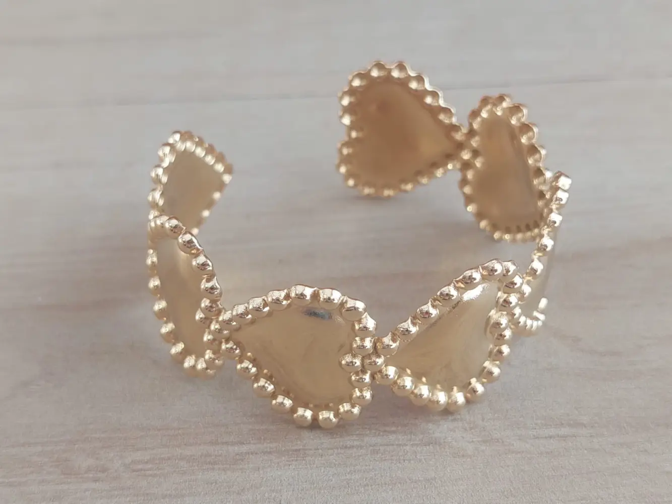 Esclava regulable de acero dorado con corazones y bolitas alrededor