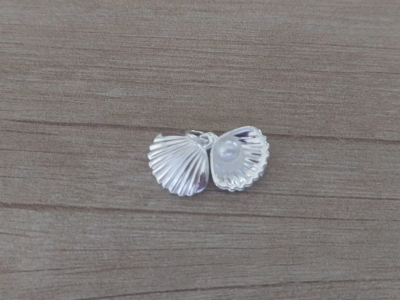 Dije de acero blanco en forma de ostra con perla en su interior