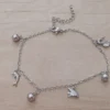 Pulsera de acero espejito con dijes de pez y bolitas