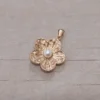 Dije de acero dorado flor con perla central