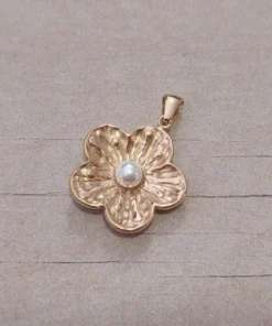 Dije de acero dorado flor con perla central