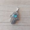 DIJE DE ACERO MANO DE FATIMA CON OJO DE GATO CELESTE. TAMAÑO 20 X 25 MM