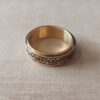 ANILLO ALIANZA DE ACERO DORADO 8 MM CON CINTA CENTRAL LABRADA GIRATORIA.