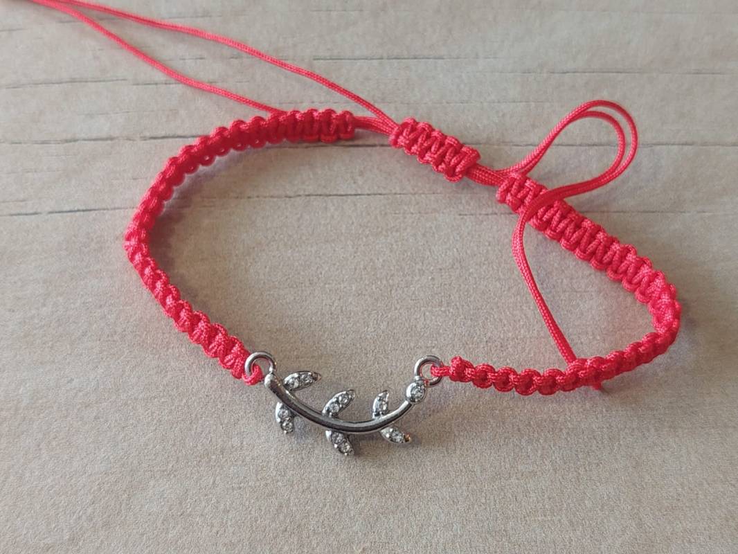 PULSERA DE HILO ROJO AJUSTABLE CON DIJE DE ACERO RAMA CON STRASS.