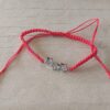 PULSERA DE HILO ROJO AJUSTABLE CON DIJE DE ACERO ESTRELLAS CON STRASS.