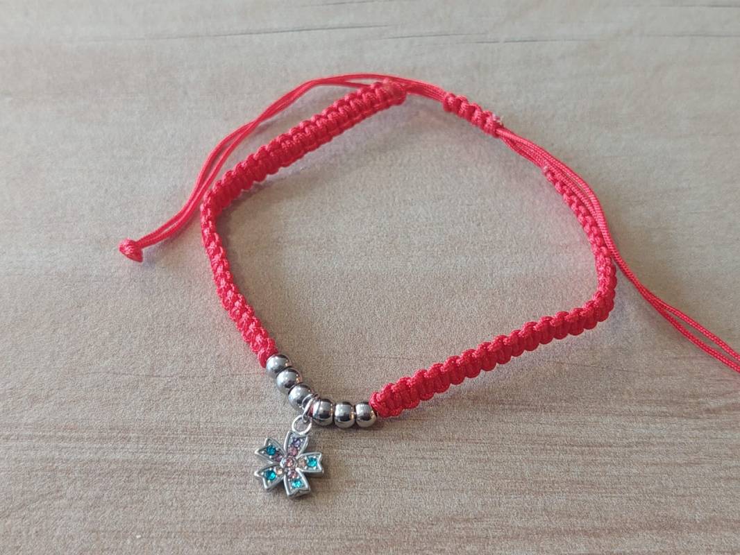 PULSERA DE HILO ROJO AJUSTABLE CON BOLITAS Y DIJE DE ACERO FLOR CON STRASS MULTICOLOR