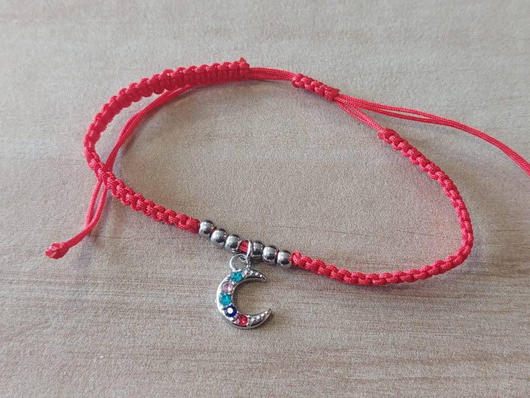 PULSERA DE HILO ROJO AJUSTABLE CON BOLITAS Y DIJE DE ACERO LUNA CON STRASS MULTICOLOR