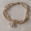 PULSERA DE ACERO DORADO DOBLE ESLABONES ALARGADOS/BOLITA CON DIJE OJO TURCO CON STRASS. LARGO 18 CM