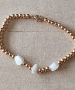 PULSERA DE ACERO DORADO BOLITAS 3 MM CON TRES NÁCAR IRREGULAR EN EL CENTRO. LARGO 18 CM.