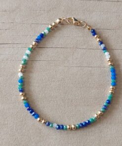 PULSERA DE TANZA CON MOSTACILLAS MULTICOLOR Y BOLITAS CON TERMINAL DE ACERO DORADO. LARGO 18,5 CM.