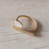 ANILLO DE ACERO DORADO ABIERTO BARRA CON OJITO DE GATO OVAL.