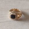 ANILLO DE ACERO DORADO ESPIGADO CON STRASS NEGRO CUADRADO Y STRASS BLANCO ALREDEDOR