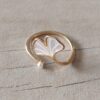 ANILLO DE ACERO DORADO ABIERTO CON FORMA DE PÉTALO CON PERLA DETALLE SÍMIL NACAR