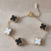 PULSERA DE ACERO DORADO ESLABÓN ESPEJITO CON DIJE ESTILO VAN CLEEF ACRÍLICO BLANCO Y NEGRO. LARGO 17,5 + 6 CM EXT.