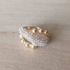 ANILLO DE ACERO DORADO DIAGONAL CON STRASS BLANCO Y BOLITAS ENTRELAZADAS