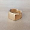ANILLO DE ACERO DORADO SELLO CUADRADO.