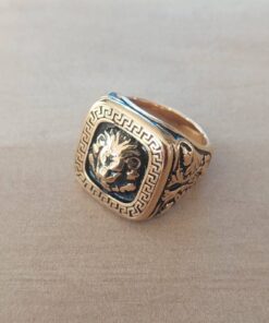 ANILLO DE ACERO DORADO ESTILO SELLO CON CABEZA DE LEON Y PATRON GRIEGO