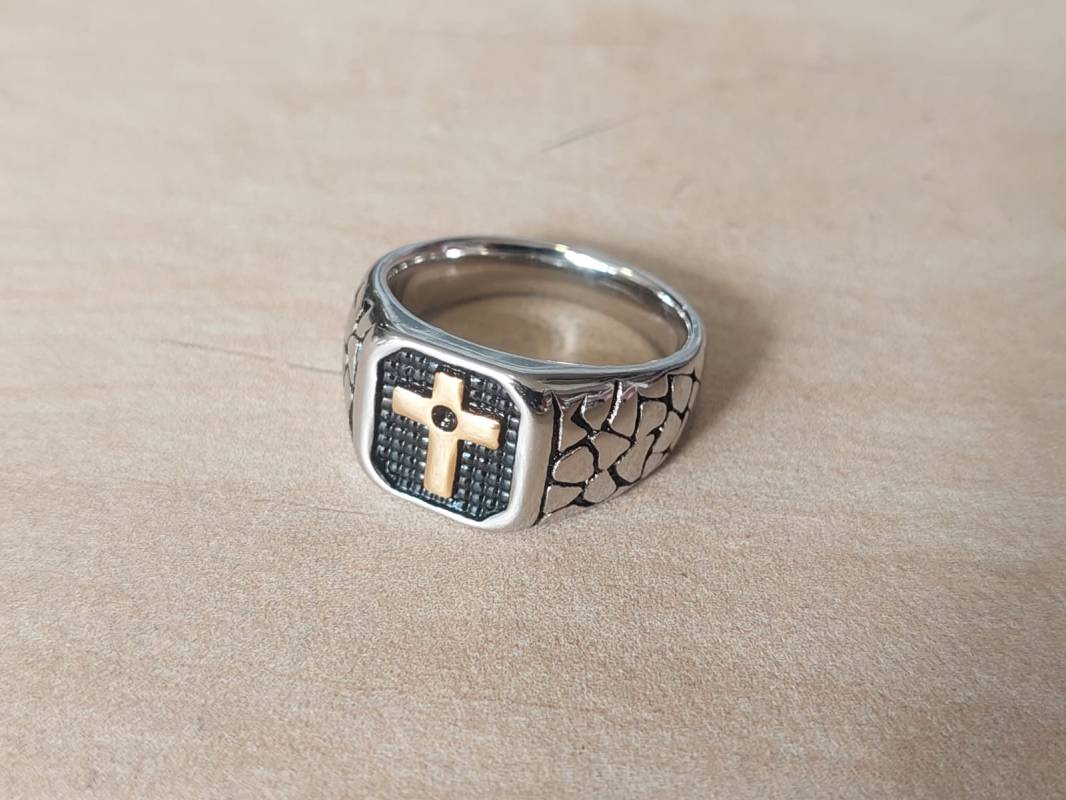 ANILLO DE ACERO ESTILO SELLO CON CRUZ DORADA Y DETALLES EN NEGRO.