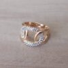ANILLO DE ACERO DORADO CON CIRCULO CON STRASS BLANCO ENTRELAZADO