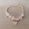PULSERA DE ACERO DORADO COLA DE RATÓN 3 MM CON DONAS GAMA ROSA Y MARIPOSA. LARGO 19 CM EXT. 3 CM