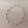 PULSERA DE TANZA CON DOS MOSTACILLAS ROSAS Y DOS BOLITAS 3 MM INTERCALADAS. TERMINAL DE ACERO DORADO. LARGO 18,5 CM.