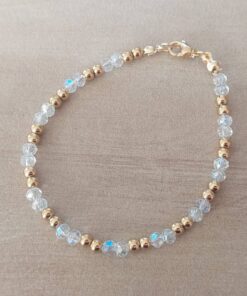 PULSERA DE TANZA CON DOS MOSTACILLAS BLANCAS Y DOS BOLITAS 3 MM INTERCALADAS. TERMINAL DE ACERO DORADO. LARGO 18,5 CM.
