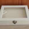 EXHIBIDOR AFELPADO PARA ANILLOS COLOR MARFIL CON TAPA TRANSPARENTE. TAMAÑO 15 X 20 X 5 CM