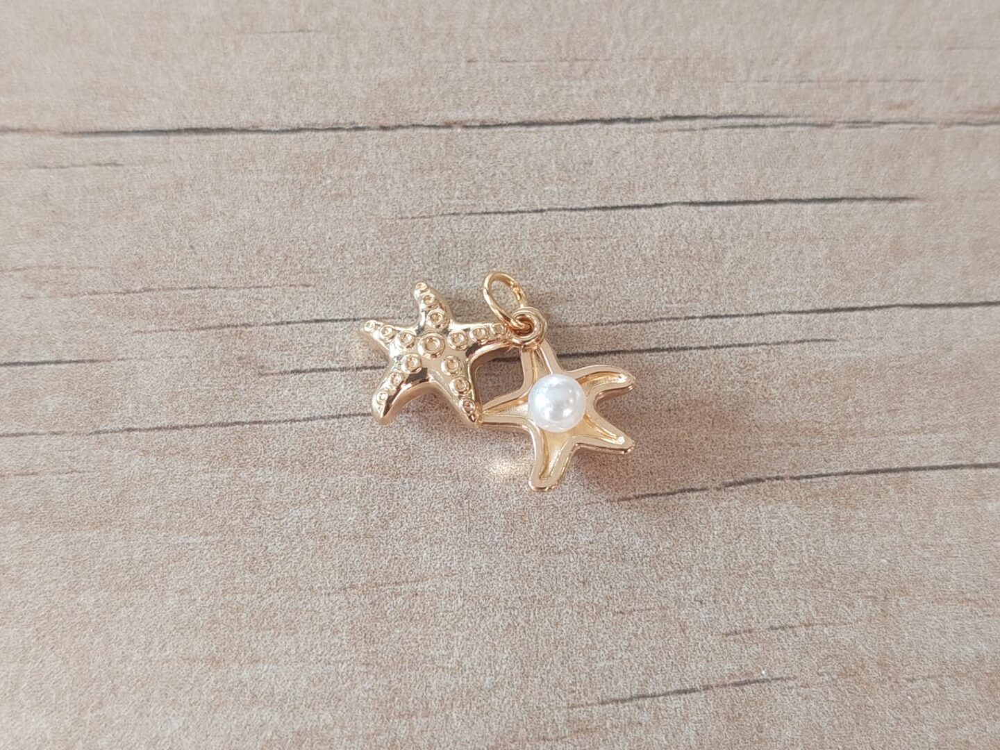 DIJE DE ACERO DORADO DOBLE ESTRELLA DE MAR CON PERLA. TAMAÑO 10 MM