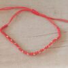 PULSERA DE HILO ROJO CON BOLITAS DE ACERO DORADO AJUSTABLE.