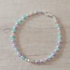 PULSERA DE TANZA CON MOSTACILLAS MULTICOLOR Y BOLITAS CON TERMINAL DE ACERO BLANCO. LARGO 18,5 CM