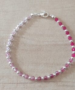 PULSERA DE TANZA CON MOSTACILLAS DEGRADE ROSA Y BOLITAS CON TERMINAL DE ACERO BLANCO. LARGO 18,5 CM