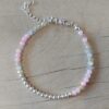 PULSERA DE TANZA CON MOSTACILLAS TONOS ROSA Y BOLITAS CON TERMINAL DE ACERO BLANCO. LARGO 16 CM + 5 EXT