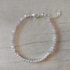 PULSERA DE TANZA CON MOSTACILLAS TONOS BEIGE Y BOLITAS CON TERMINAL DE ACERO BLANCO. LARGO 16 CM + 5 EXT