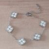 PULSERA DE ACERO ESLABÓN ESPEJITO CON DIJES TRÉBOL NACARADO. LARGO 17,5 + 6 CM EXT.