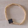 PULSERA DE ACERO DORADO ELASTIZADA CON BOLITAS 3 MM Y DIJE CENTRAL ESTILO VAN CLEEF NEGRO.