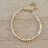 PULSERA DE TANZA CON MOSTACILLAS TONOS BEIGE Y BOLITAS CON TERMINAL DE ACERO DORADO. LARGO 16 CM + 5 EXT