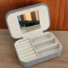 ESTUCHE ALHAJERO RECTANGULAR DE CUERINA CON CIERRE Y ESPEJO COLOR GRIS. MEDIDAS 16 X 11 CM